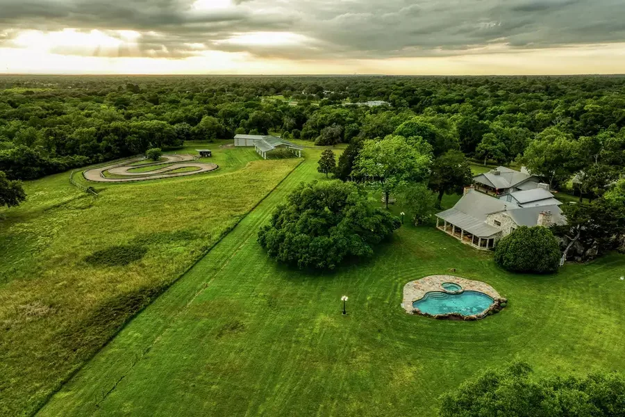 Aerial view of Twin Oaks Resort: pool, ranch house, and go-kart track