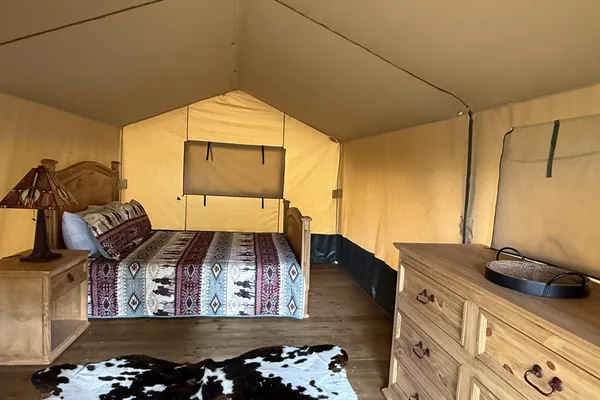 Glamping tent interior with rustic bed
