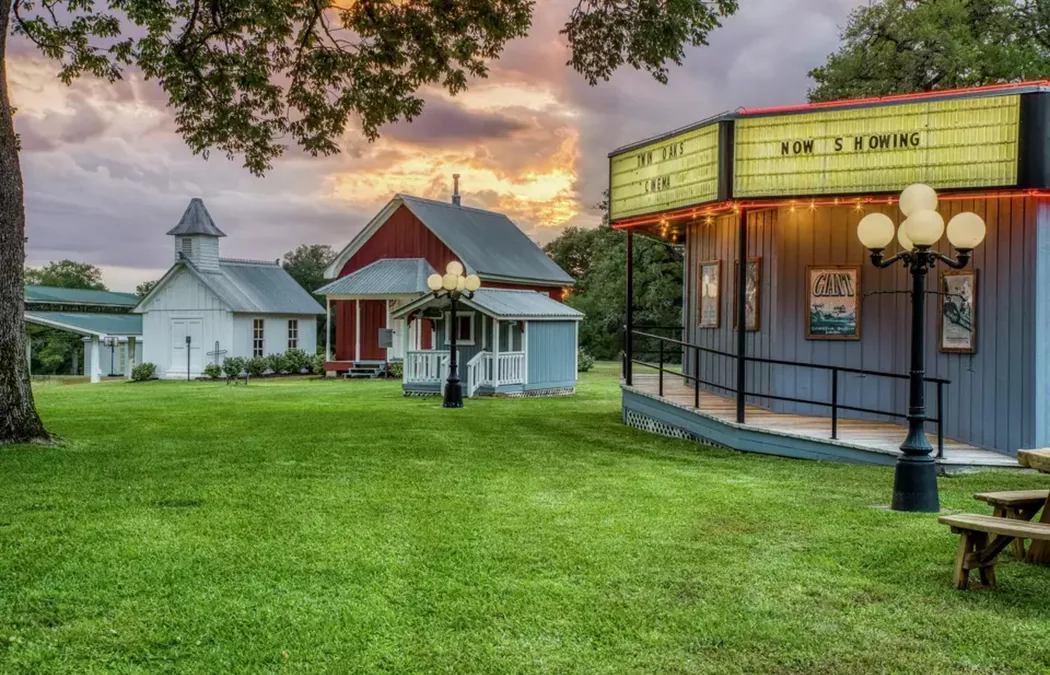 The western main street at dusk: cinema, chapel, and schoolhouse