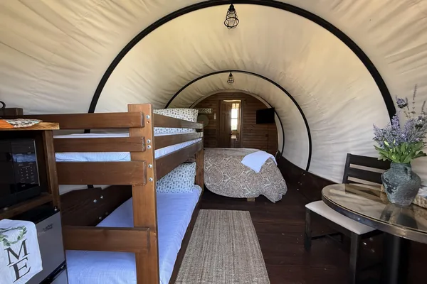 Wagon interior with queen bed and bunks