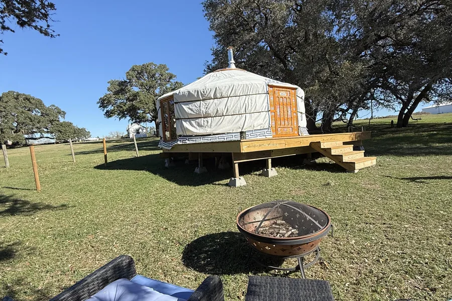 Mongolian yurt on its deck by the fire pit